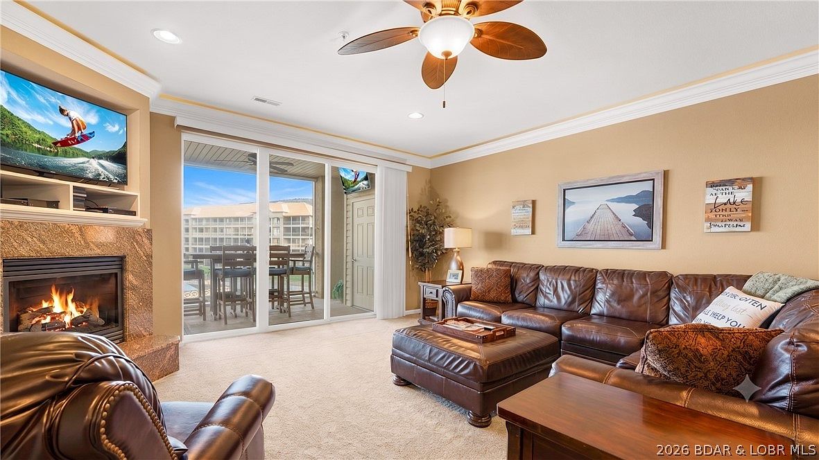 Living room with stone fireplace and lake balcony